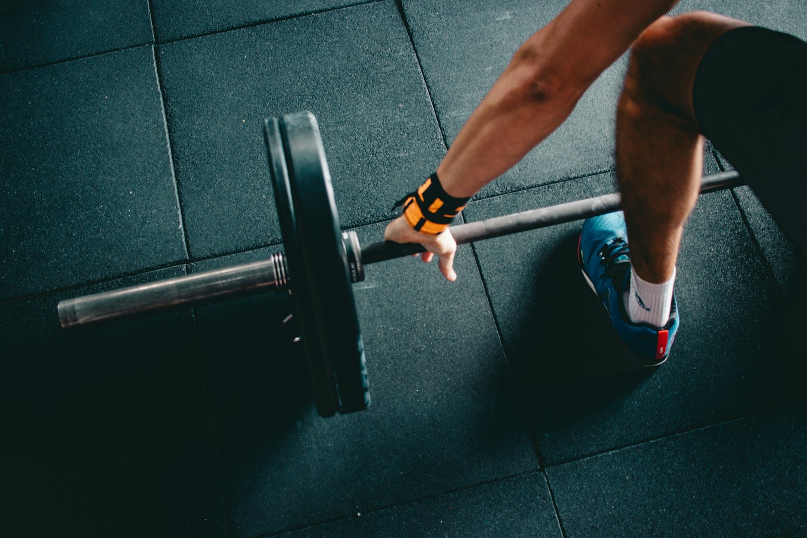 Atleta amarrando o tênis pronto para treinar em qualquer academia